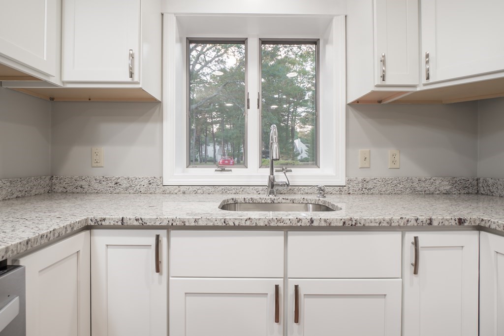 4 Shellback Way, Unit A4 Mashpee, MA 02649 - Photo 7 of 30 a kitchen with granite countertop stainless steel appliances white cabinets and a window