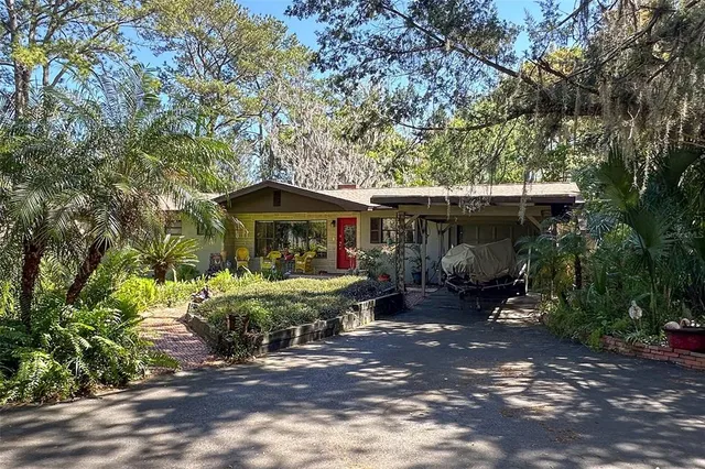 a view of house with table and chairs under an umbrella