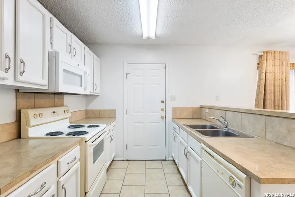 a kitchen with stainless steel appliances granite countertop a sink and a stove