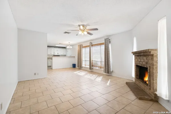 a view of empty room with a fireplace and window