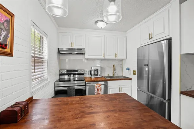 a kitchen with stainless steel appliances a stove a refrigerator and a sink