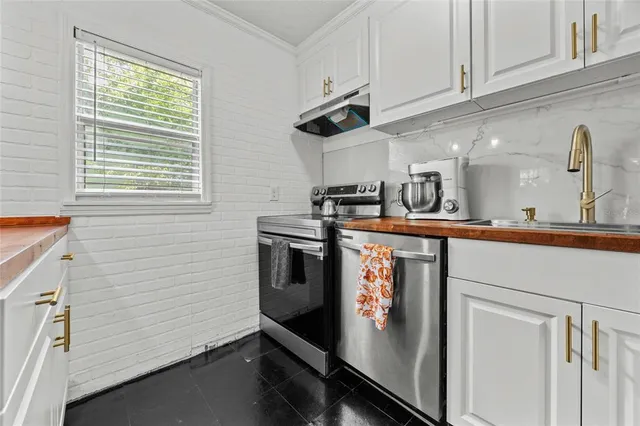 a kitchen with stainless steel appliances granite countertop a sink a stove and a refrigerator