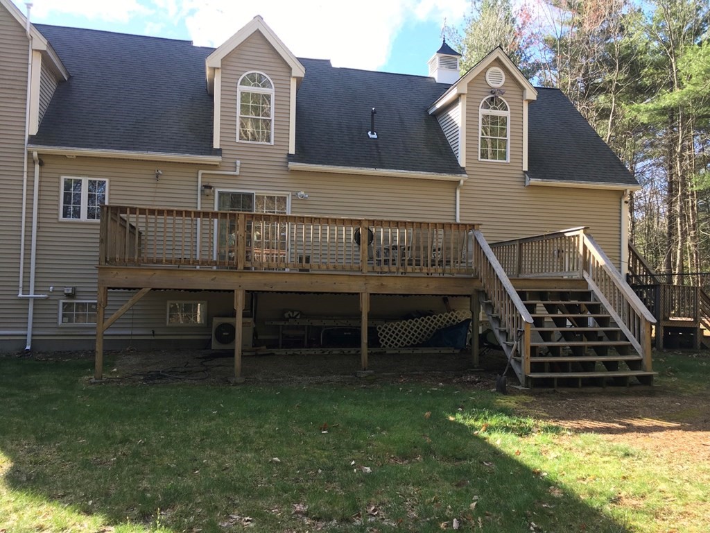 320 Putnam Hill Road Sutton, MA 01590 - Photo 31 of 40 a view of a house with a wooden deck and a yard