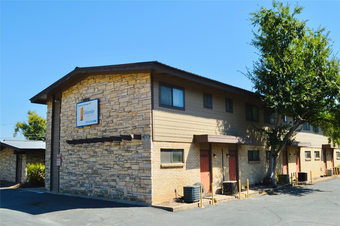 View of front of house featuring cooling unit, brick siding, and stone​​‌​​​​‌​​‌‌​‌‌​​‌​​​​‌​​​‌‌​‌‌‌ siding