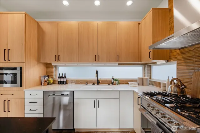 a kitchen with stainless steel appliances a stove a sink and cabinets