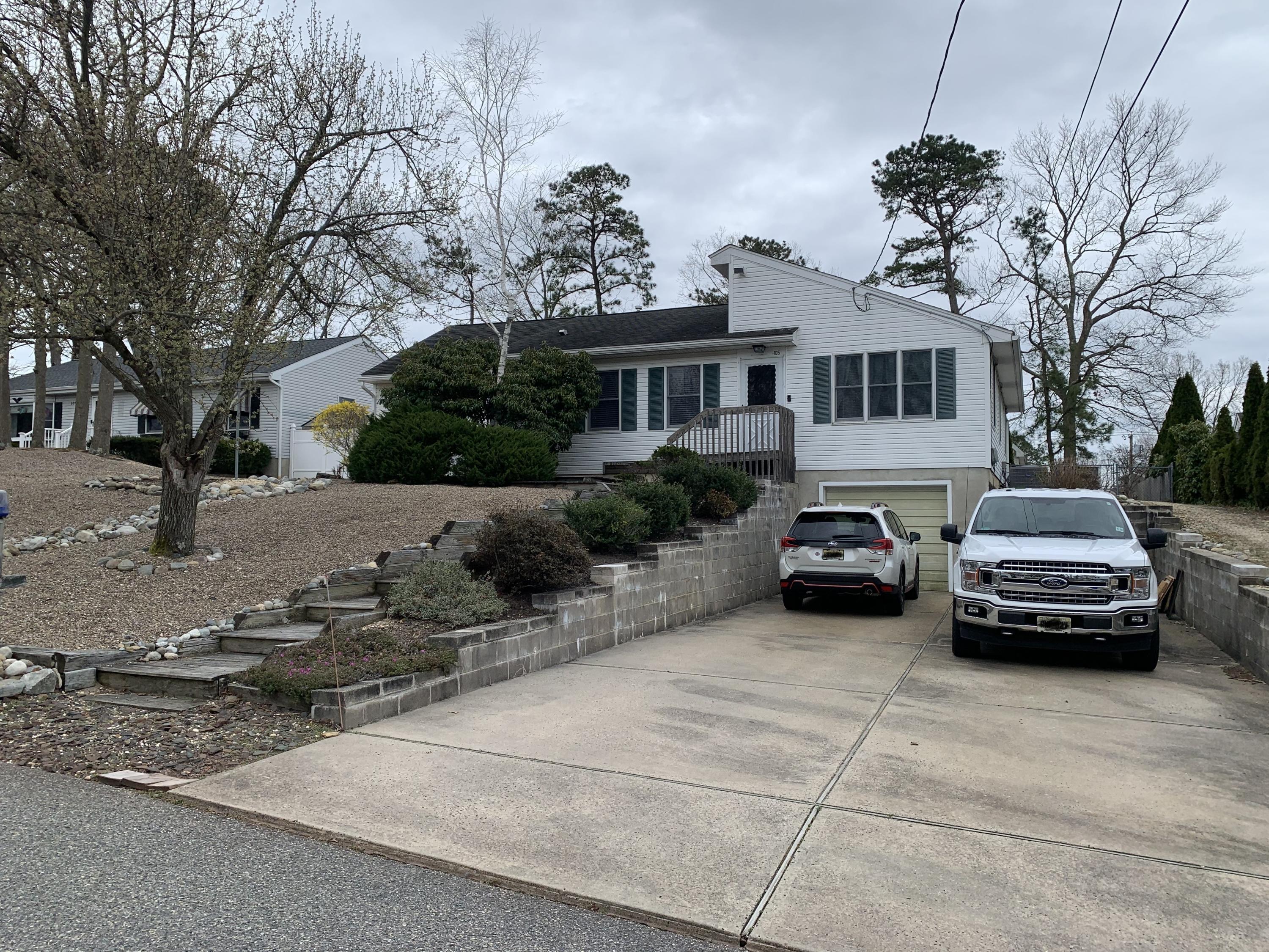 105 Seaspray Road Manahawkin, NJ 08050 - Photo 1 of 25 a car parked in front of white house