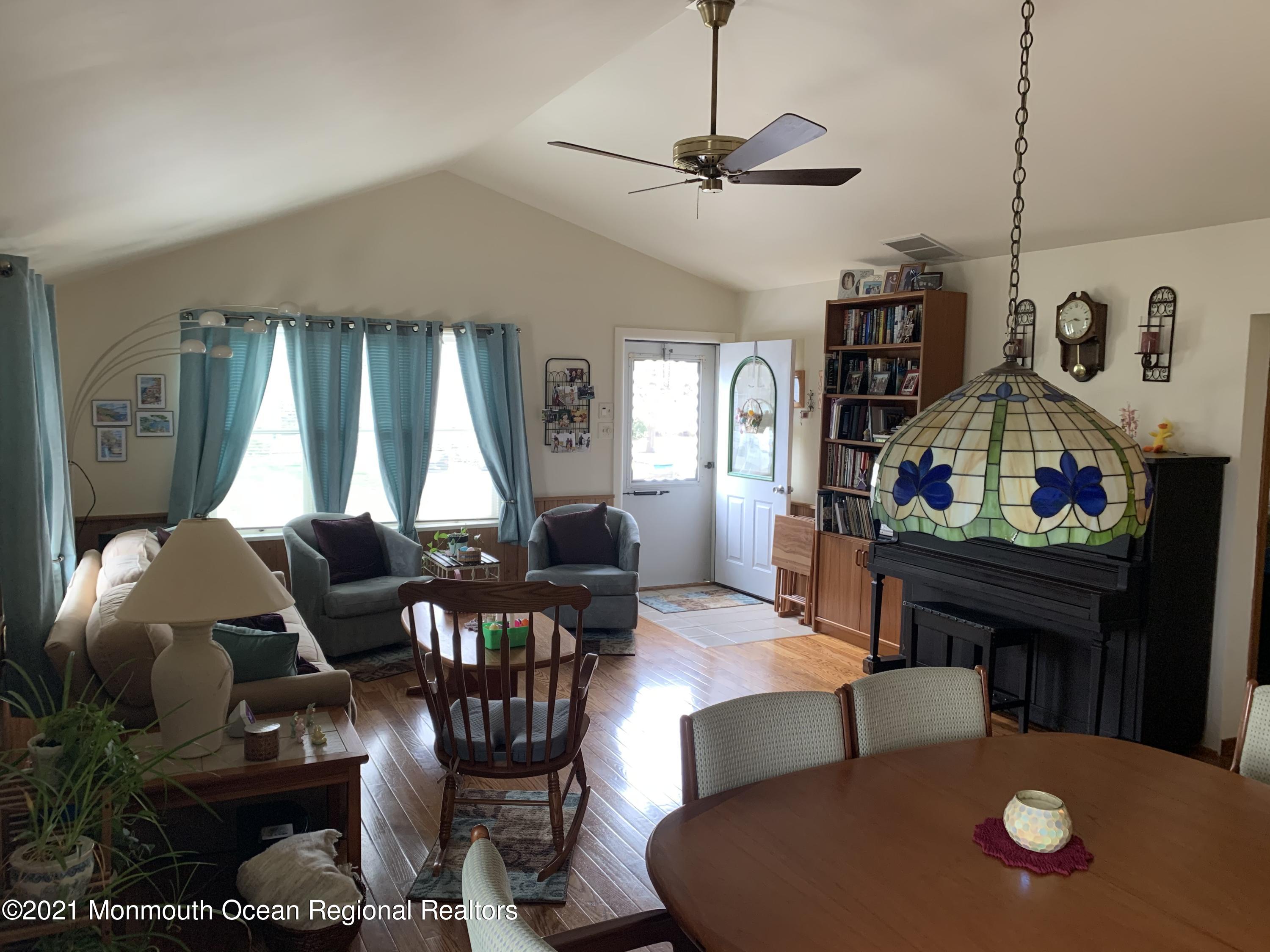 105 Seaspray Road Manahawkin, NJ 08050 - Photo 12 of 25 a living room with furniture a chandelier and a dining table