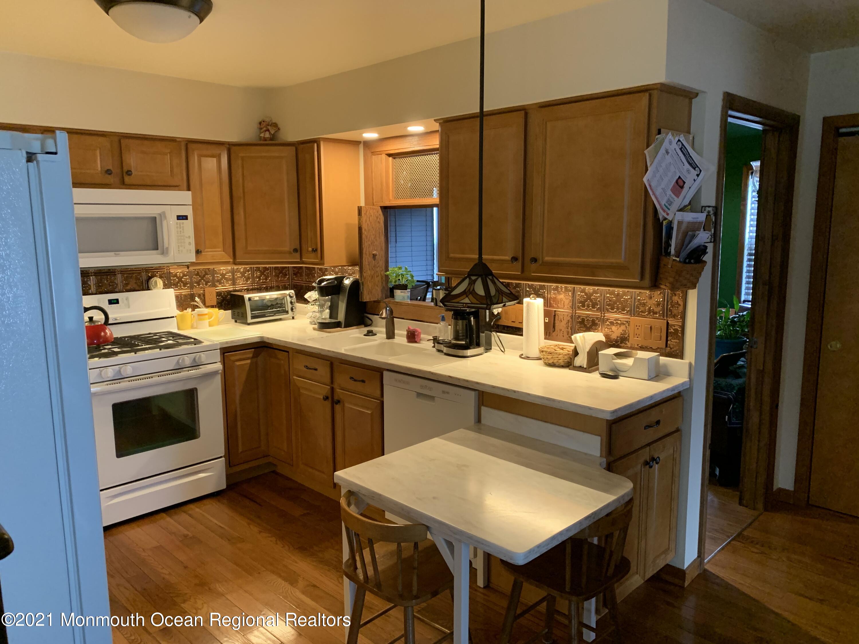 105 Seaspray Road Manahawkin, NJ 08050 - Photo 13 of 25 a kitchen with a sink stove and cabinets