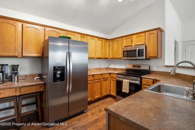 a kitchen with stainless steel appliances granite countertop a refrigerator a stove top oven a sink and dishwasher