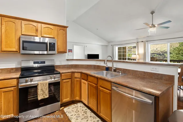 a kitchen with granite countertop a stove sink and microwave