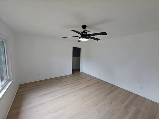 a view of a small space with wooden floor and a ceiling fan
