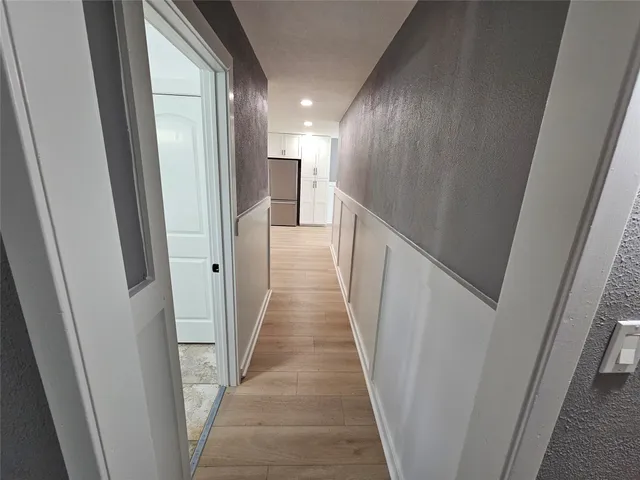 a view of a hallway with wooden floor