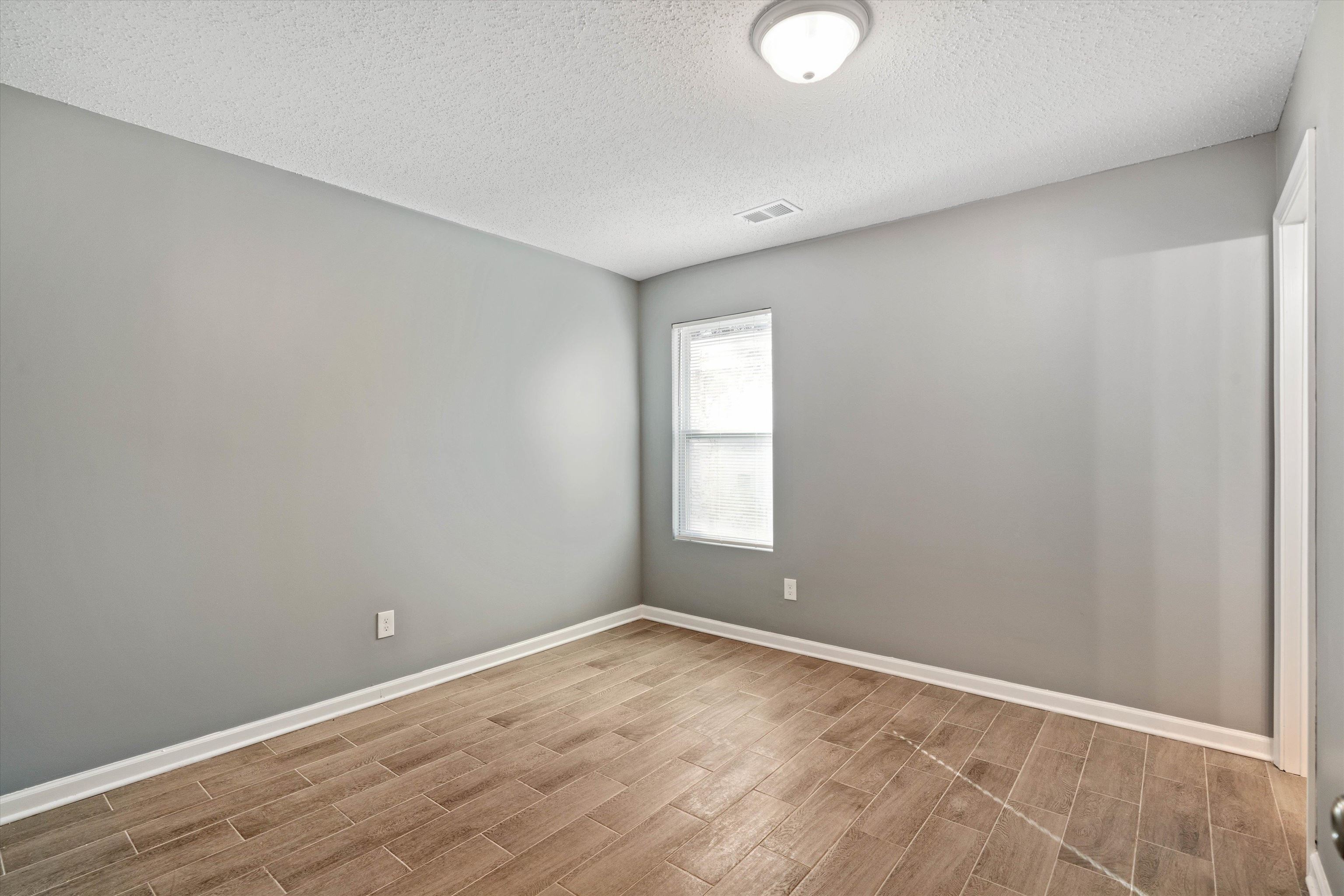 487 Delta Road Memphis, TN 38109 - Photo 17 of 25 a view of an empty room with wooden floor and a window