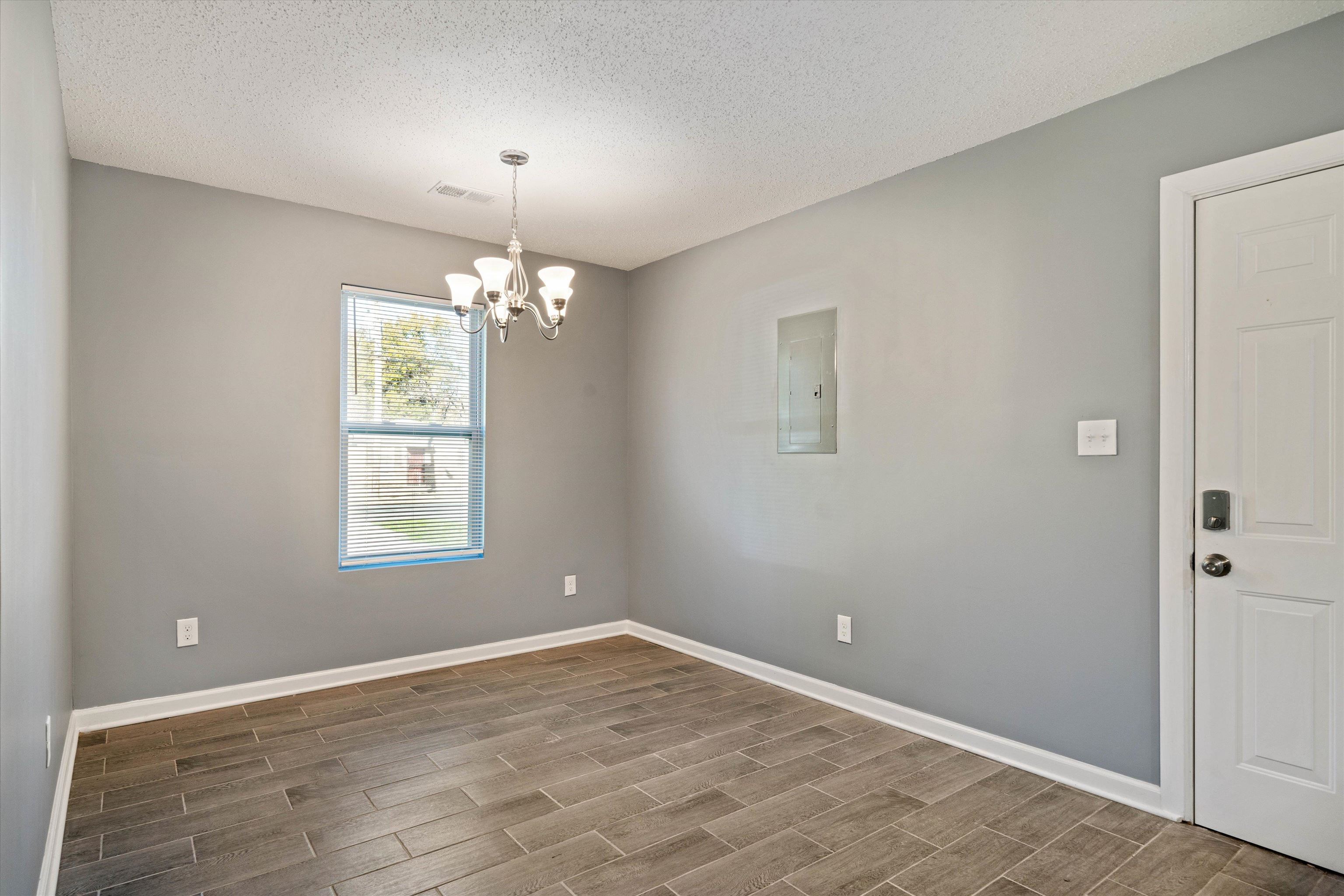 487 Delta Road Memphis, TN 38109 - Photo 7 of 25 an empty room with chandelier and windows
