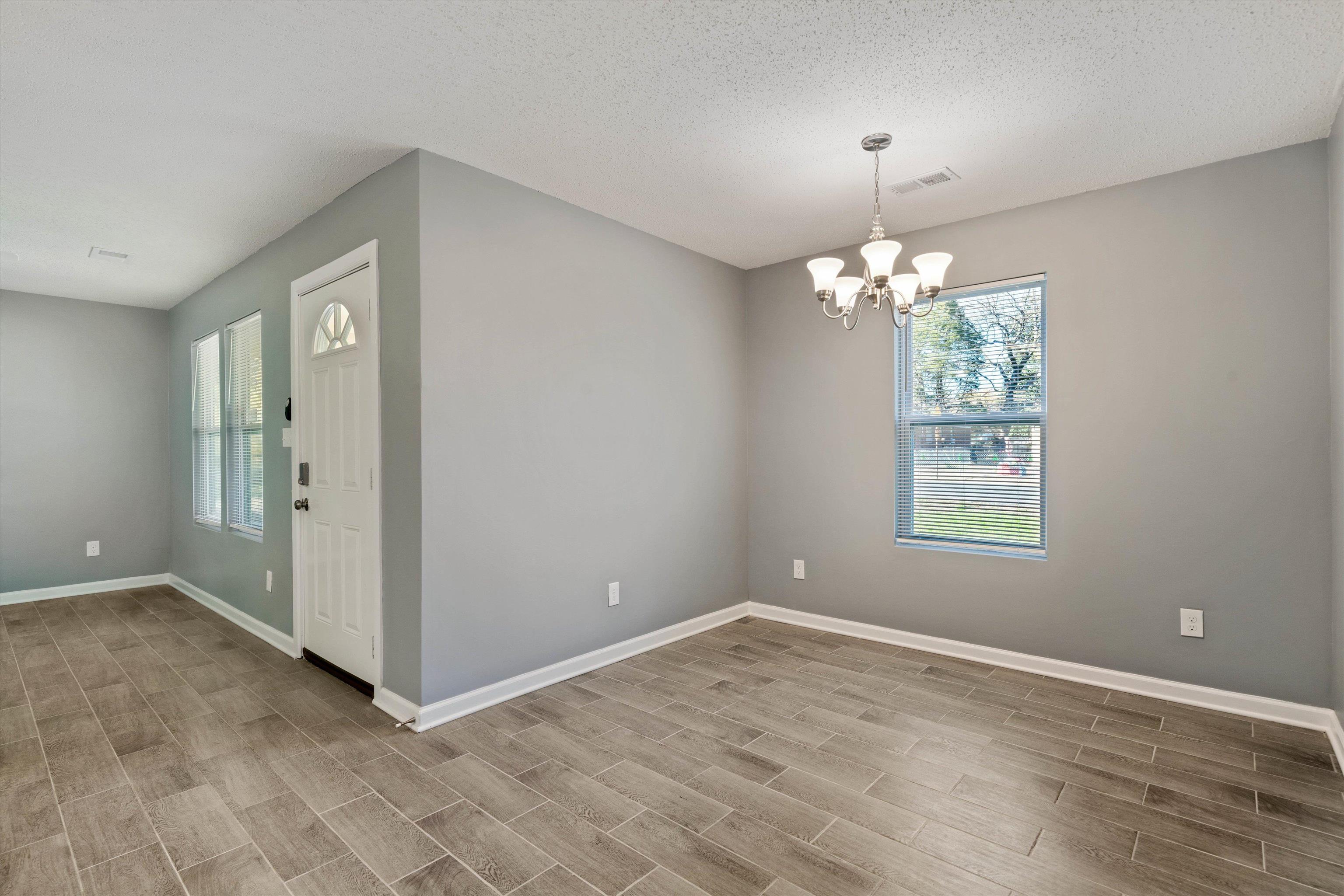 487 Delta Road Memphis, TN 38109 - Photo 8 of 25 an empty room with chandelier fan and windows