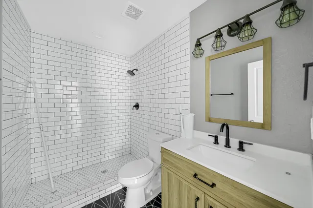 a bathroom with a sink a toilet and shower