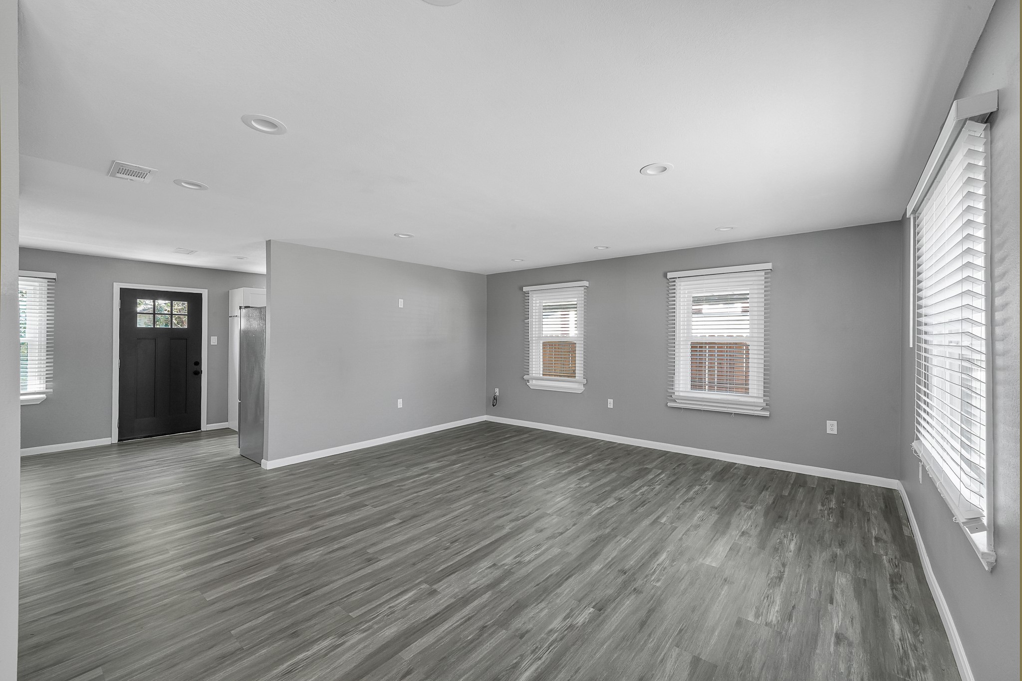 7323 Farnsworth Street Houston, TX 77022 - Photo 3 of 23 an empty room with wooden floor and windows