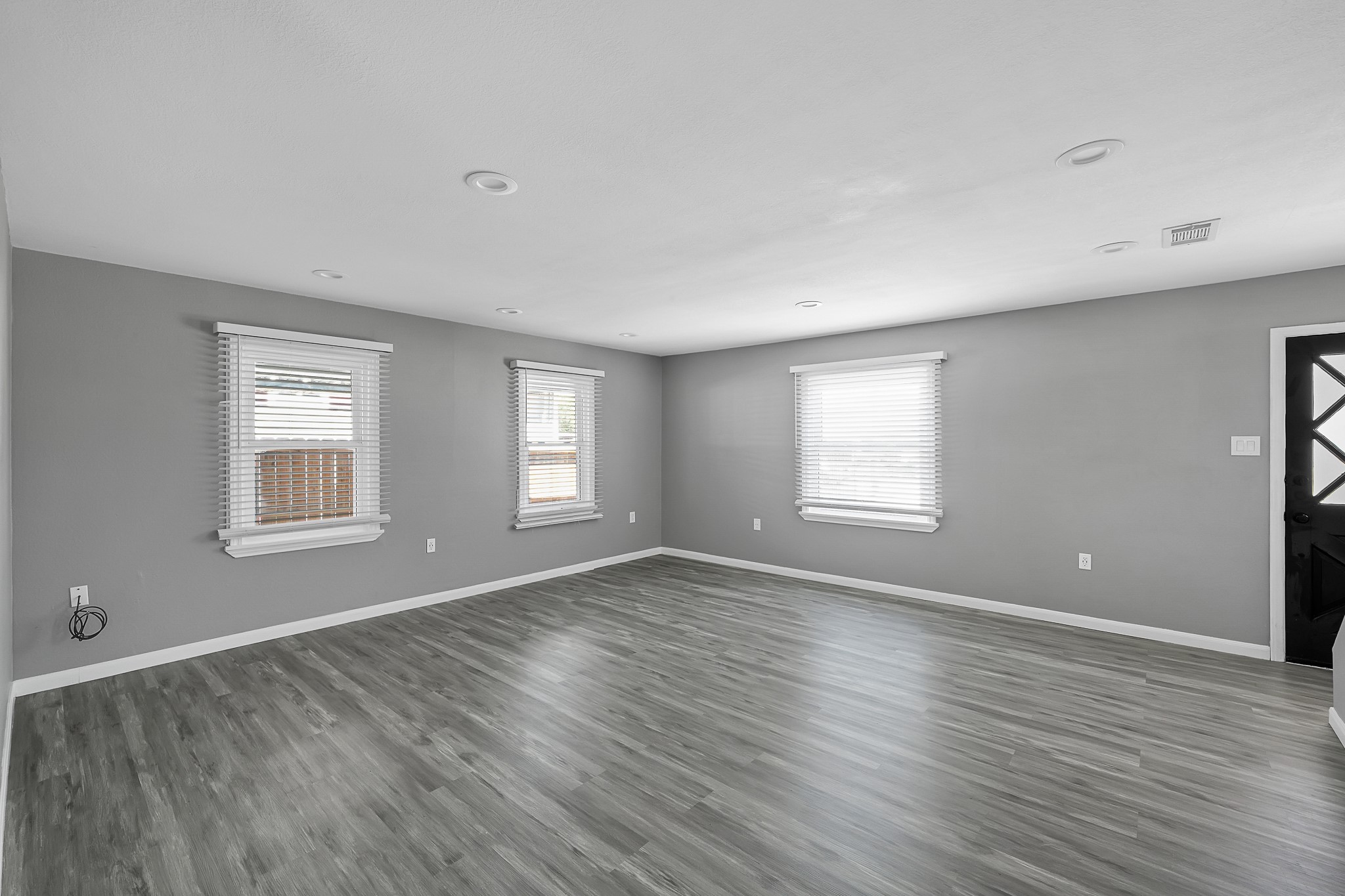 7323 Farnsworth Street Houston, TX 77022 - Photo 5 of 23 an empty room with wooden floor and windows