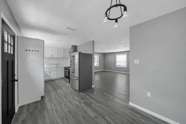 a view of a kitchen with a refrigerator and wooden floor