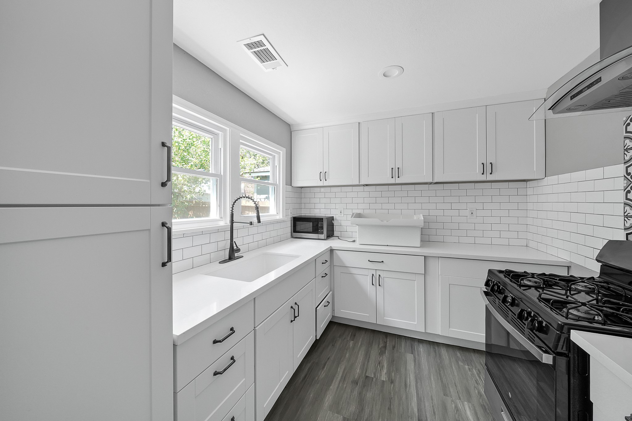 7323 Farnsworth Street Houston, TX 77022 - Photo 9 of 23 a kitchen with cabinets appliances a sink and a window