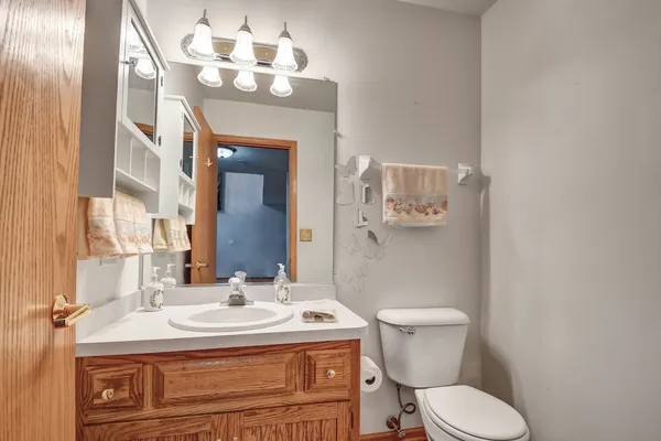 a bathroom with a granite countertop toilet sink and mirror