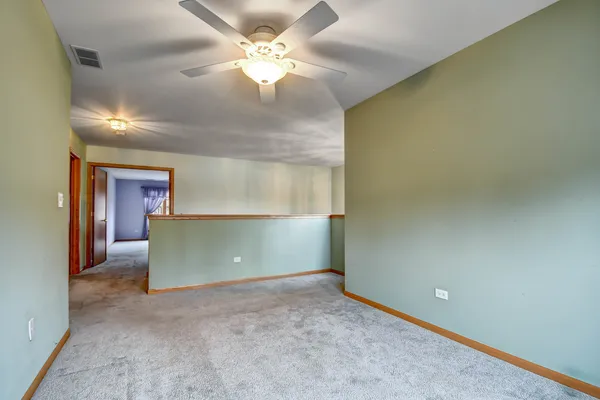 an empty room with a ceiling fan and a window