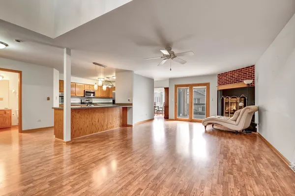 a view of open kitchen with kitchen island wooden floors and stainless steel appliances
