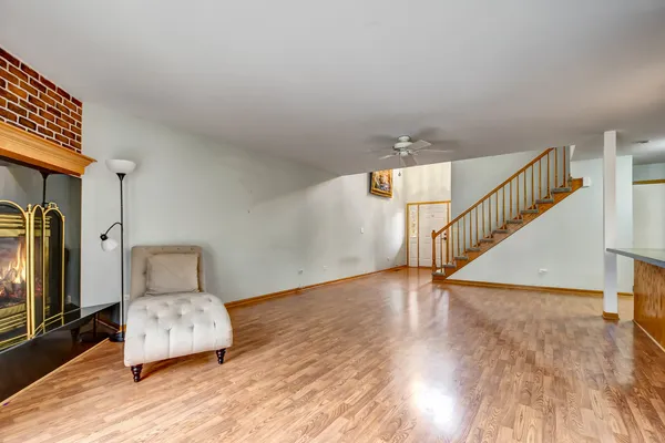 a view of a livingroom with wooden floor and stairs
