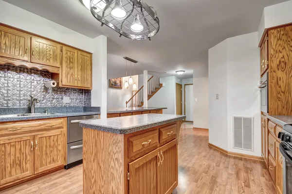 a kitchen with a sink cabinets and wooden floor