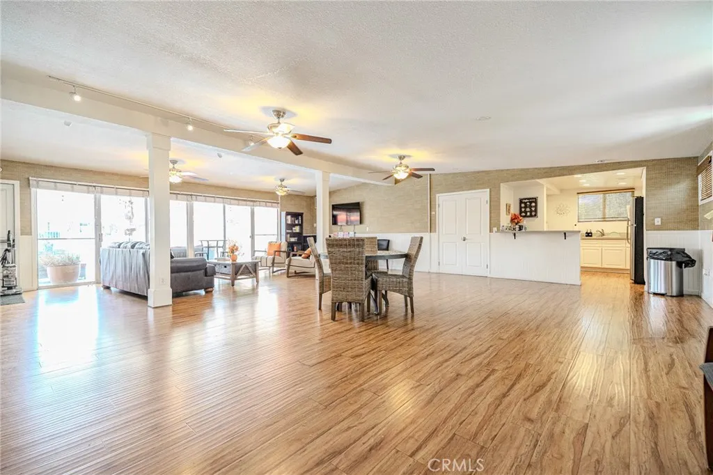 9340 Foothill, Unit 68 Rancho Cucamonga, CA 91730 - Photo 25 of 30 a dining room with wooden floor a chandelier a glass table and chairs