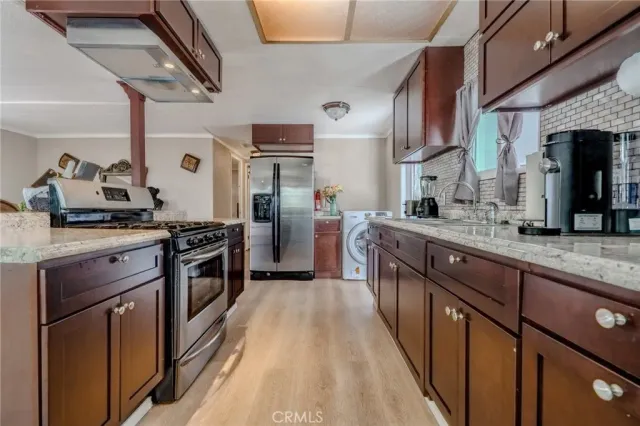a kitchen with stainless steel appliances granite countertop a sink a stove and a refrigerator