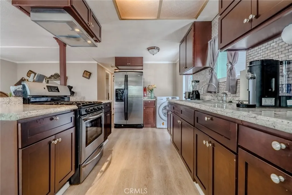 9340 Foothill, Unit 68 Rancho Cucamonga, CA 91730 - Photo 5 of 30 a kitchen with stainless steel appliances granite countertop a sink a stove and a refrigerator