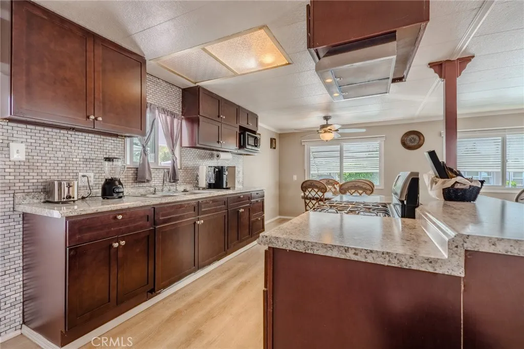 9340 Foothill, Unit 68 Rancho Cucamonga, CA 91730 - Photo 6 of 30 a kitchen with granite countertop a sink dishwasher stove and cabinets