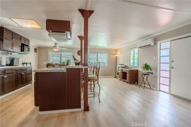 a kitchen with a table chairs refrigerator and a window
