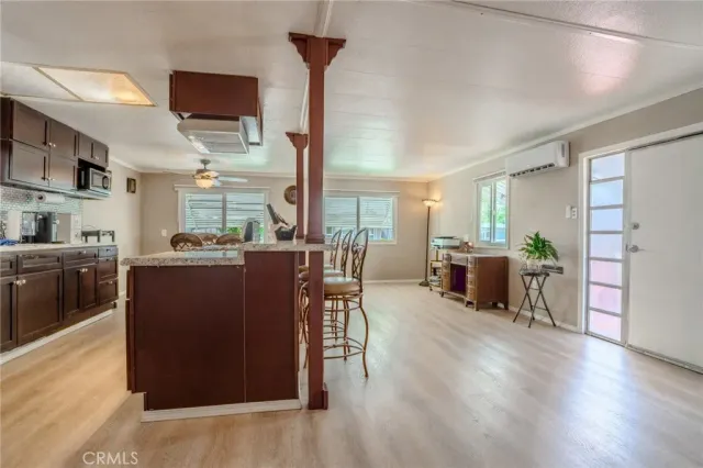 a living room with furniture wooden floor and a kitchen view