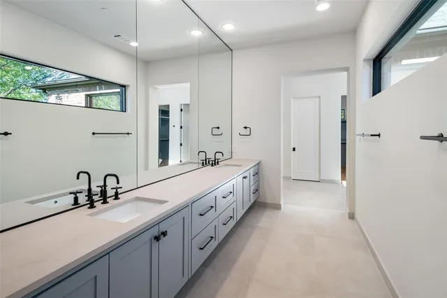a spacious bathroom with double vanity and mirrors