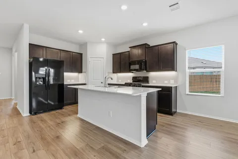 a kitchen with stainless steel appliances granite countertop a stove a sink and a refrigerator