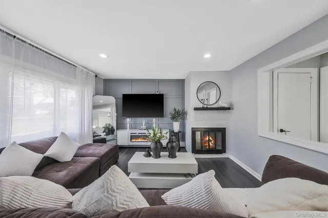 a living room with furniture a fireplace and a flat screen tv
