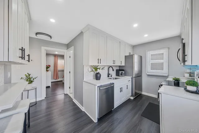 a kitchen with white cabinets and white appliances