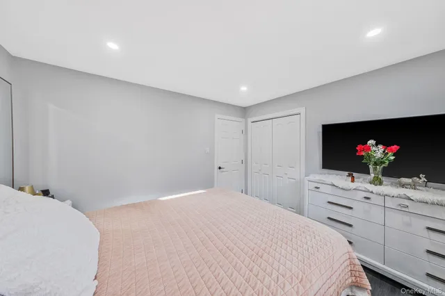 a bedroom with a bed and a flat screen tv