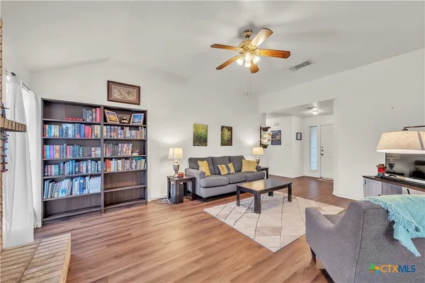 a living room with furniture and a book shelf