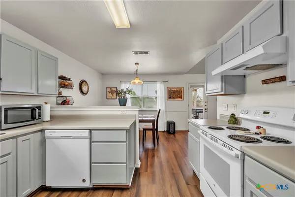 a kitchen with cabinets and steel appliances