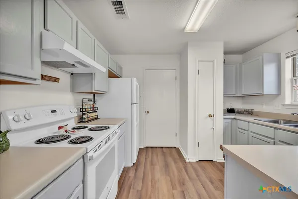 a kitchen with stainless steel appliances a stove a sink and a refrigerator