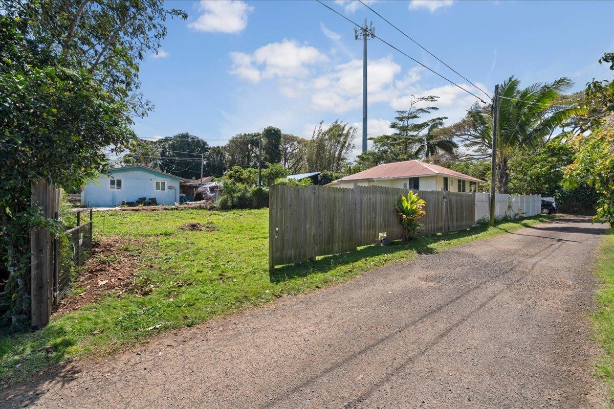 956 Kahealani Street Haiku, HI 96708 - Photo 11 of 27 a view of a back yard with flower plants and wooden fence