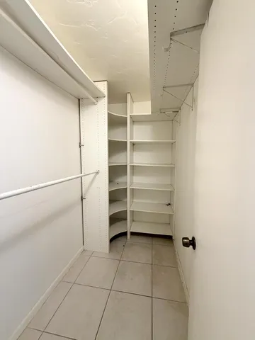 a view of walk in closet with empty racks