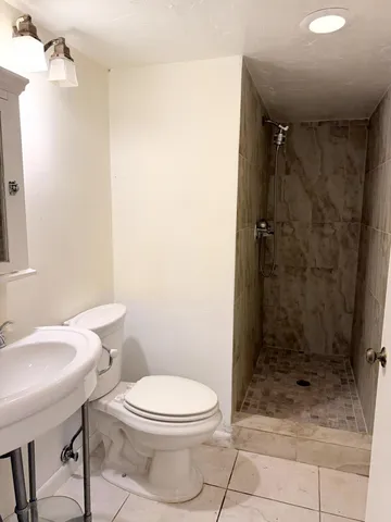 a bathroom with a toilet a sink and shower