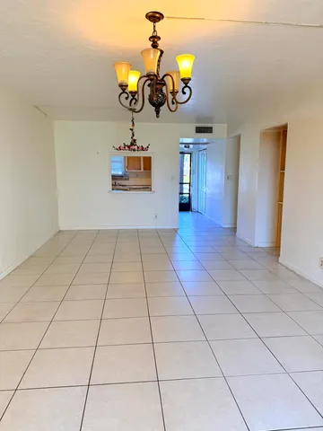 a view of a room with wooden floor and chandelier