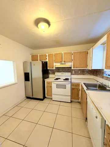 a kitchen with a stove a sink and a refrigerator