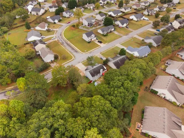 an aerial view of residential houses with outdoor space and parking