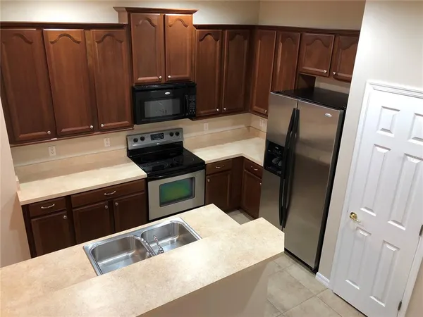 a view of kitchen with sink refrigerator and microwave